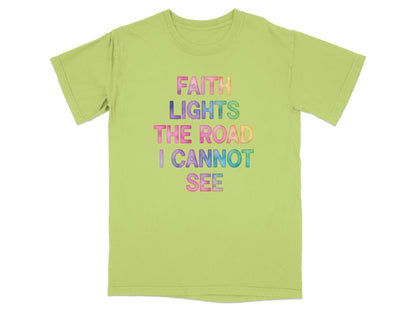 Light green t-shirt with colorful text reading "FAITH LIGHTS THE ROAD I CANNOT SEE".