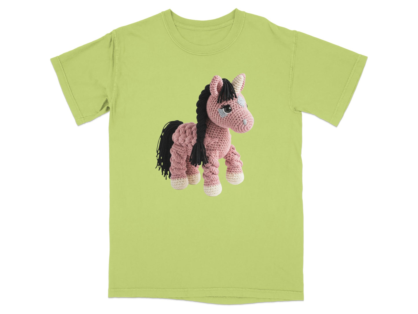 Crocheted unicorn with pink yarn, black mane, and white hooves on a light green t-shirt.