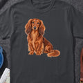 Long-haired dachshund with auburn fur sitting on a dark gray shirt.