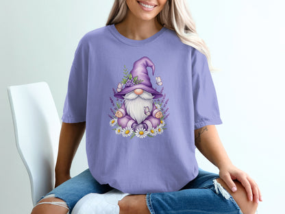Purple t-shirt with a whimsical gnome wearing a pointed hat, surrounded by daisies and butterflies.