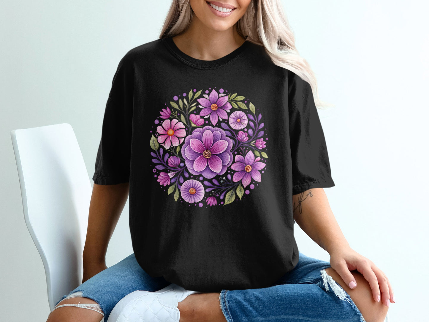 Black t-shirt with a circular floral design of purple and pink flowers.