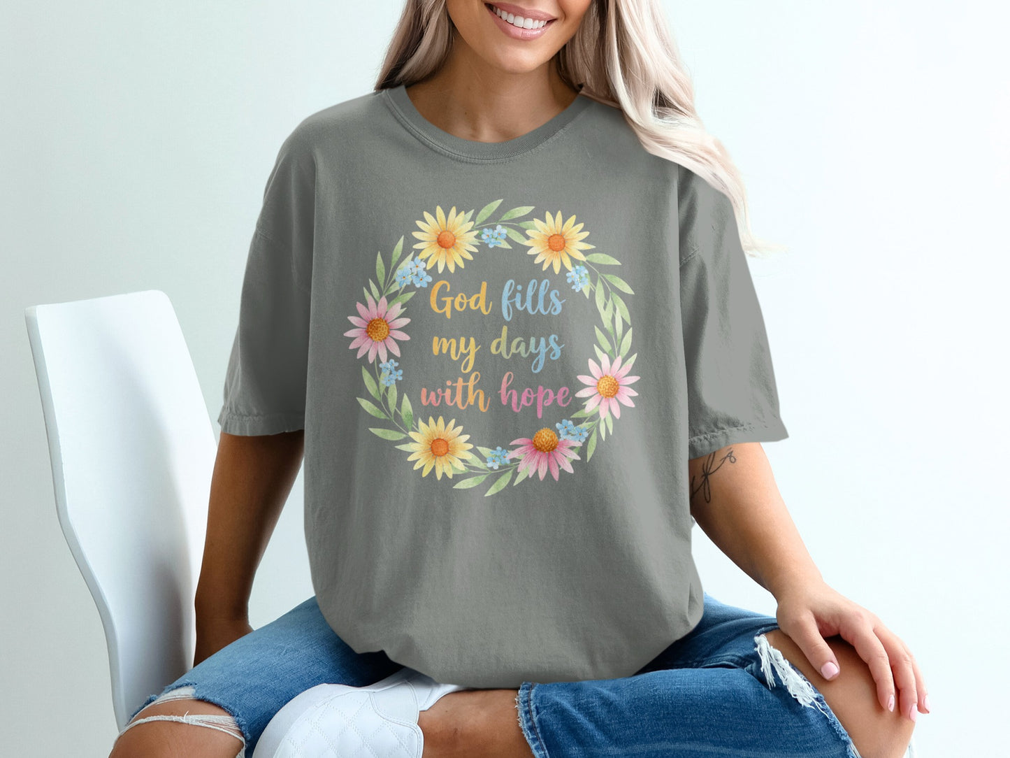 Grey t-shirt with floral wreath and "God fills my days with hope" text.