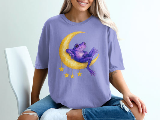 Purple frog sitting on a crescent moon with yellow stars.