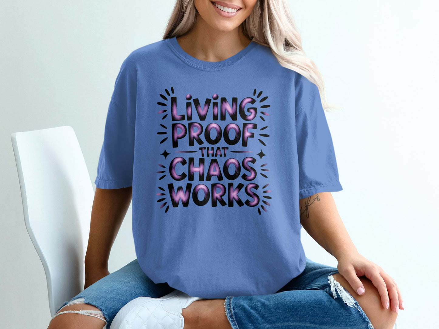 Periwinkle t-shirt with black text that reads "Living Proof That Chaos Works".