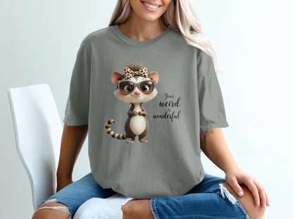 Gray t-shirt with cartoon opossum wearing glasses and a bow, saying "Your weird is wonderful."