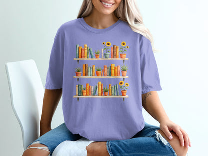 T-shirt with watercolor bookshelf and potted sunflowers graphic.