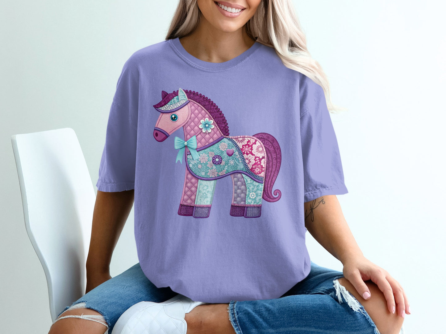Lavender t-shirt with a patchwork horse graphic and blue bow.