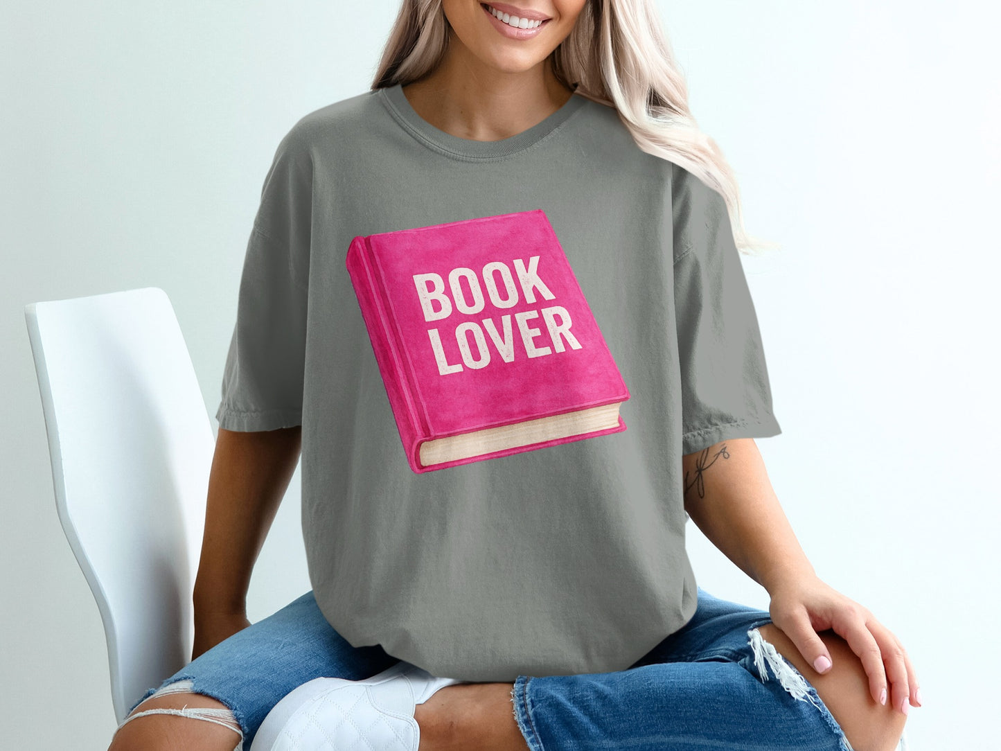 Pink book illustration with "BOOK LOVER" text on grey t-shirt.