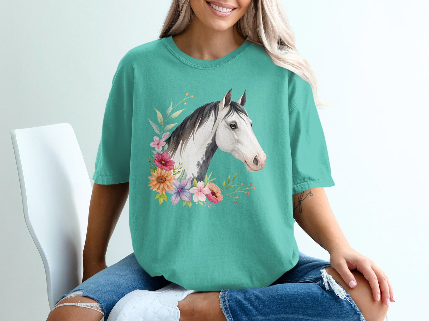 Teal t-shirt with a floral horse head graphic on the chest.