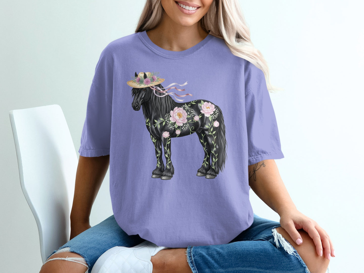 Purple t-shirt with black horse adorned with flowers and a straw hat.