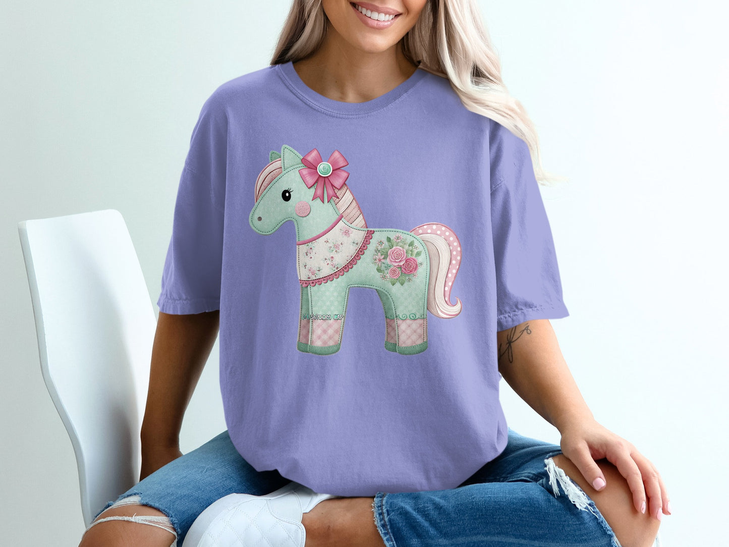 Purple t-shirt with a patchwork horse graphic and pink bow.