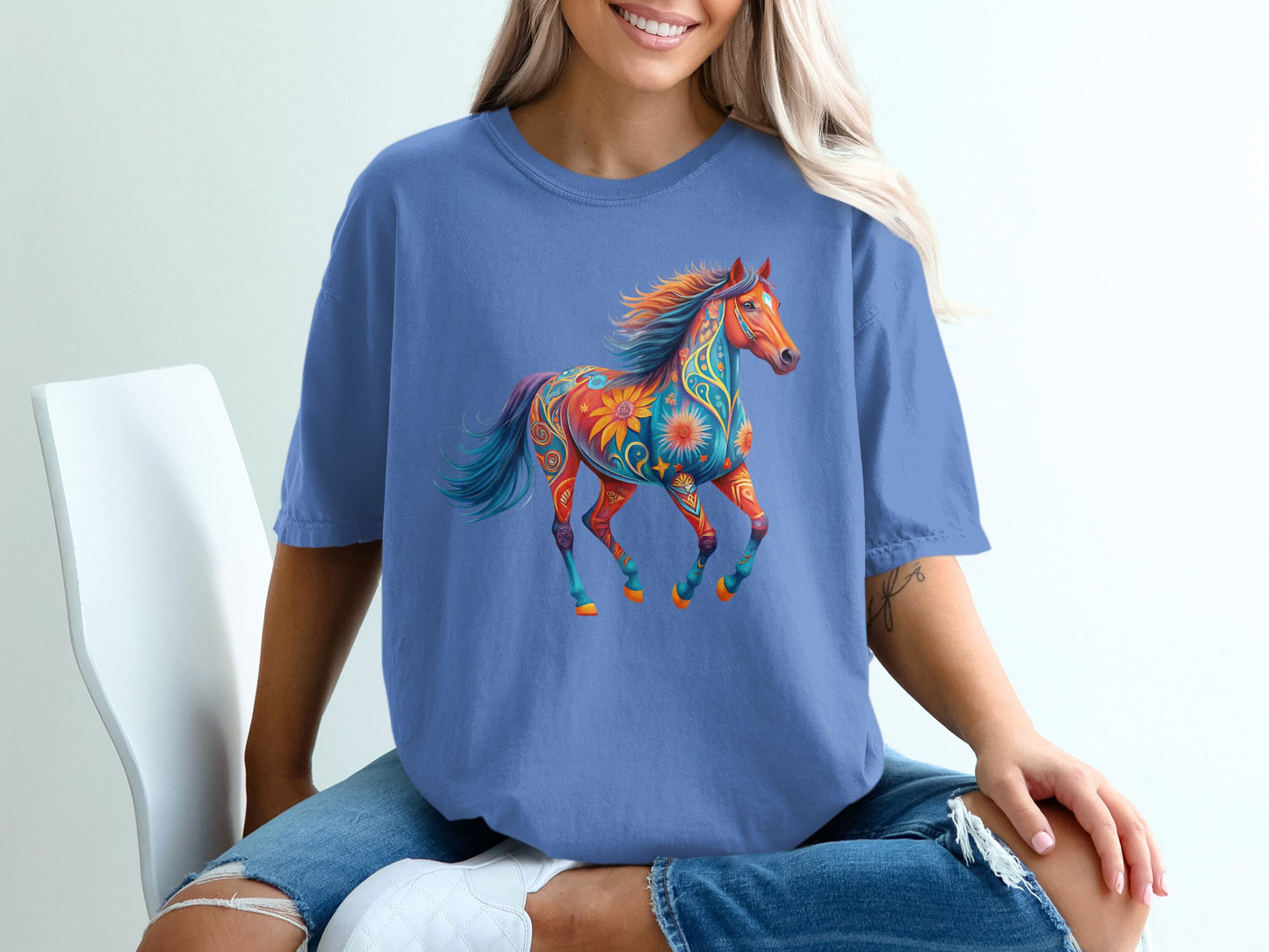 Blue t-shirt with a colorful, patterned horse graphic.