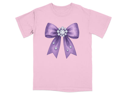 Pink t-shirt with a large purple bow decorated with rhinestones.