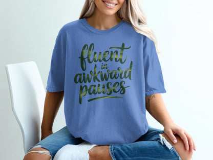 Blue t-shirt with "fluent in awkward pauses" text in green brushstrokes.