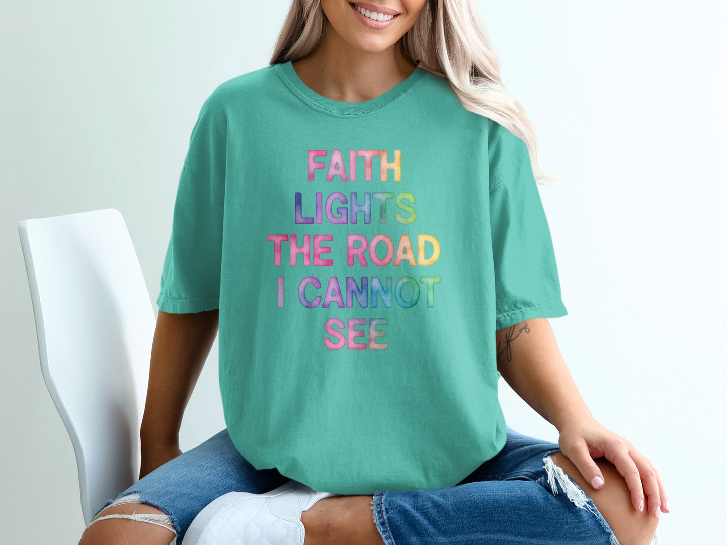 Teal t-shirt with "FAITH LIGHTS THE ROAD I CANNOT SEE" in rainbow gradient.