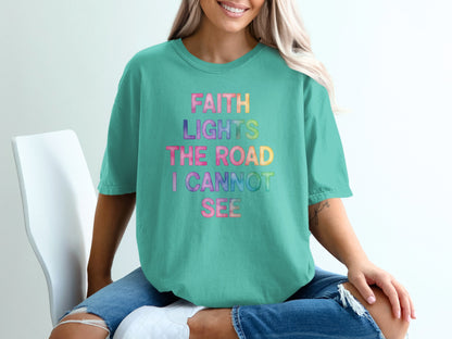 Teal t-shirt with "FAITH LIGHTS THE ROAD I CANNOT SEE" in rainbow gradient.