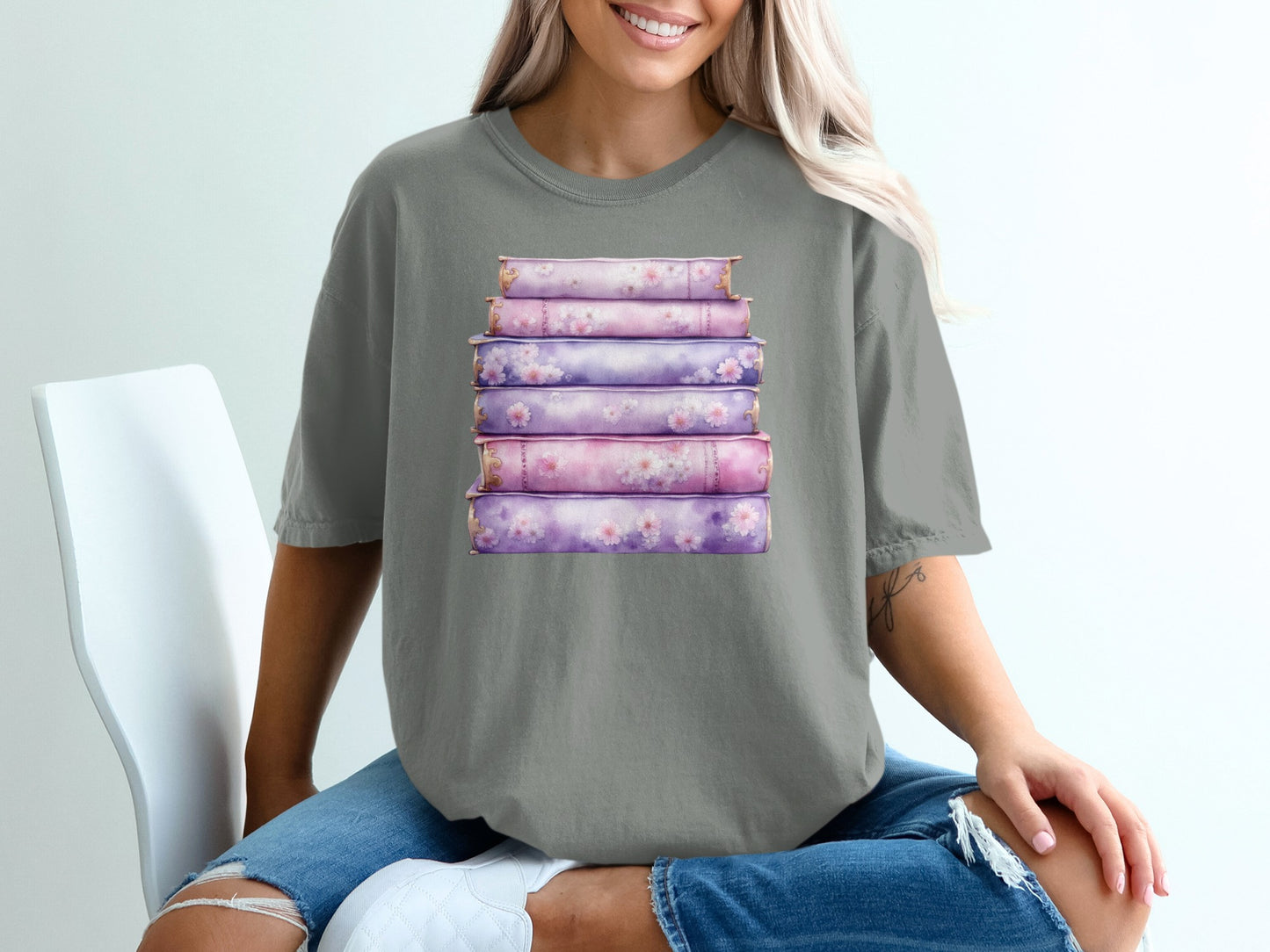 Stack of purple floral-decorated books on a grey t-shirt.