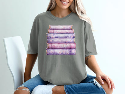 Stack of purple floral-decorated books on a grey t-shirt.