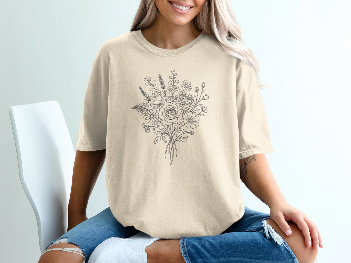 Cream t-shirt with a delicate line drawing of a floral bouquet.