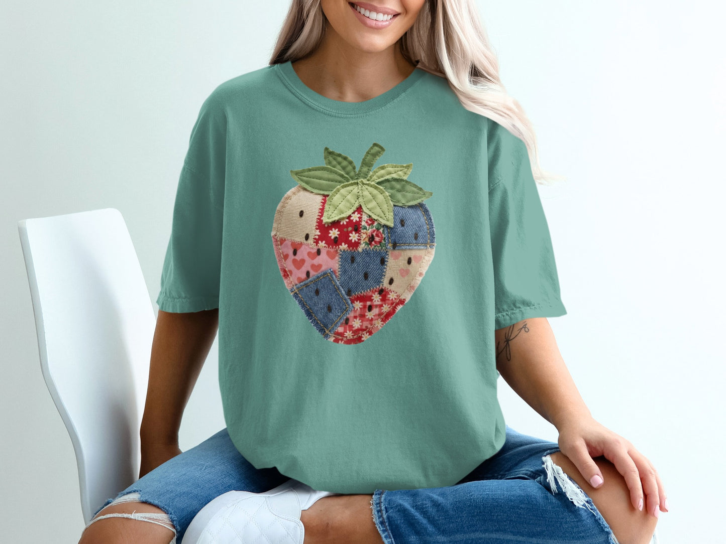 Teal t-shirt with a strawberry patch design.