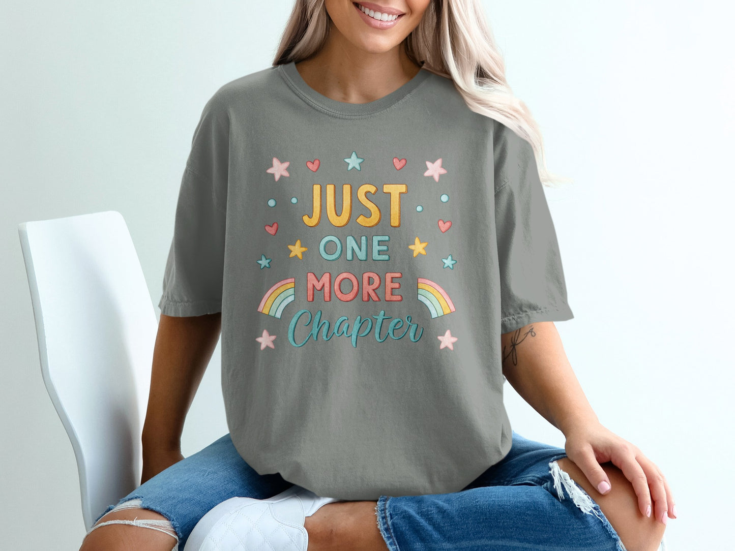 Gray t-shirt with "Just One More Chapter" text and stars.