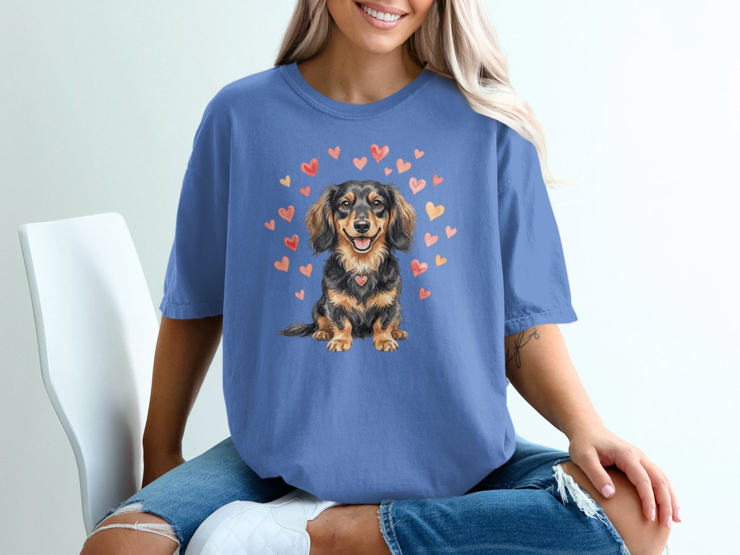 Blue t-shirt with a dachshund illustration surrounded by hearts.