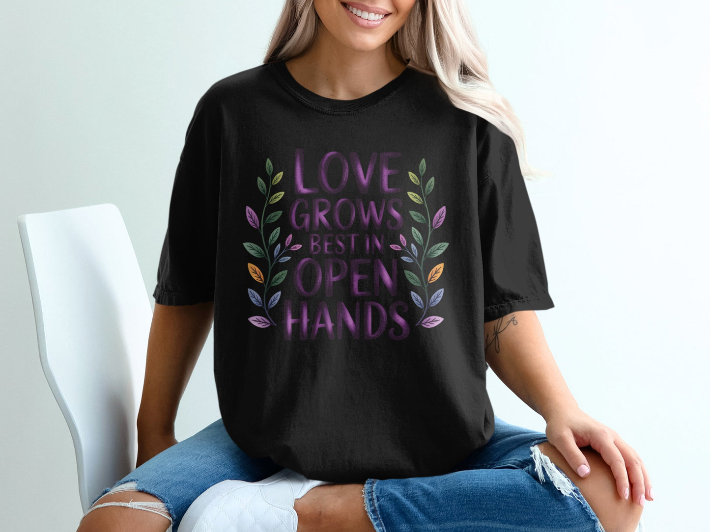 Black t-shirt with "Love Grows Best in Open Hands" text and floral design.