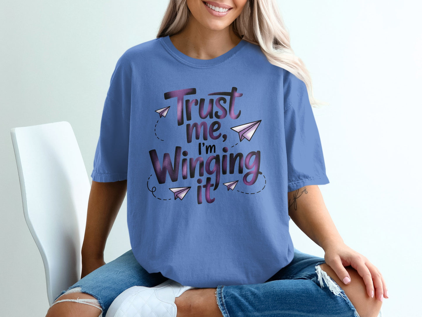 Purple t-shirt with "Trust me, I'm winging it" text and paper airplanes.