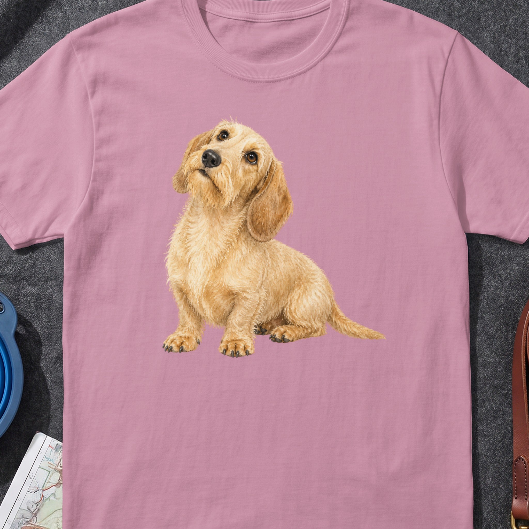 Pink t-shirt with a watercolor illustration of a scruffy wirehaired dachshund sitting.