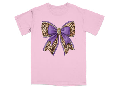 Purple glitter bow with leopard print accents on pink t-shirt.