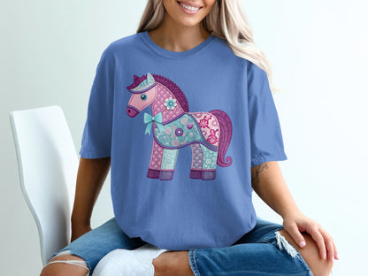 Purple t-shirt with a patchwork horse graphic wearing a blue bow.