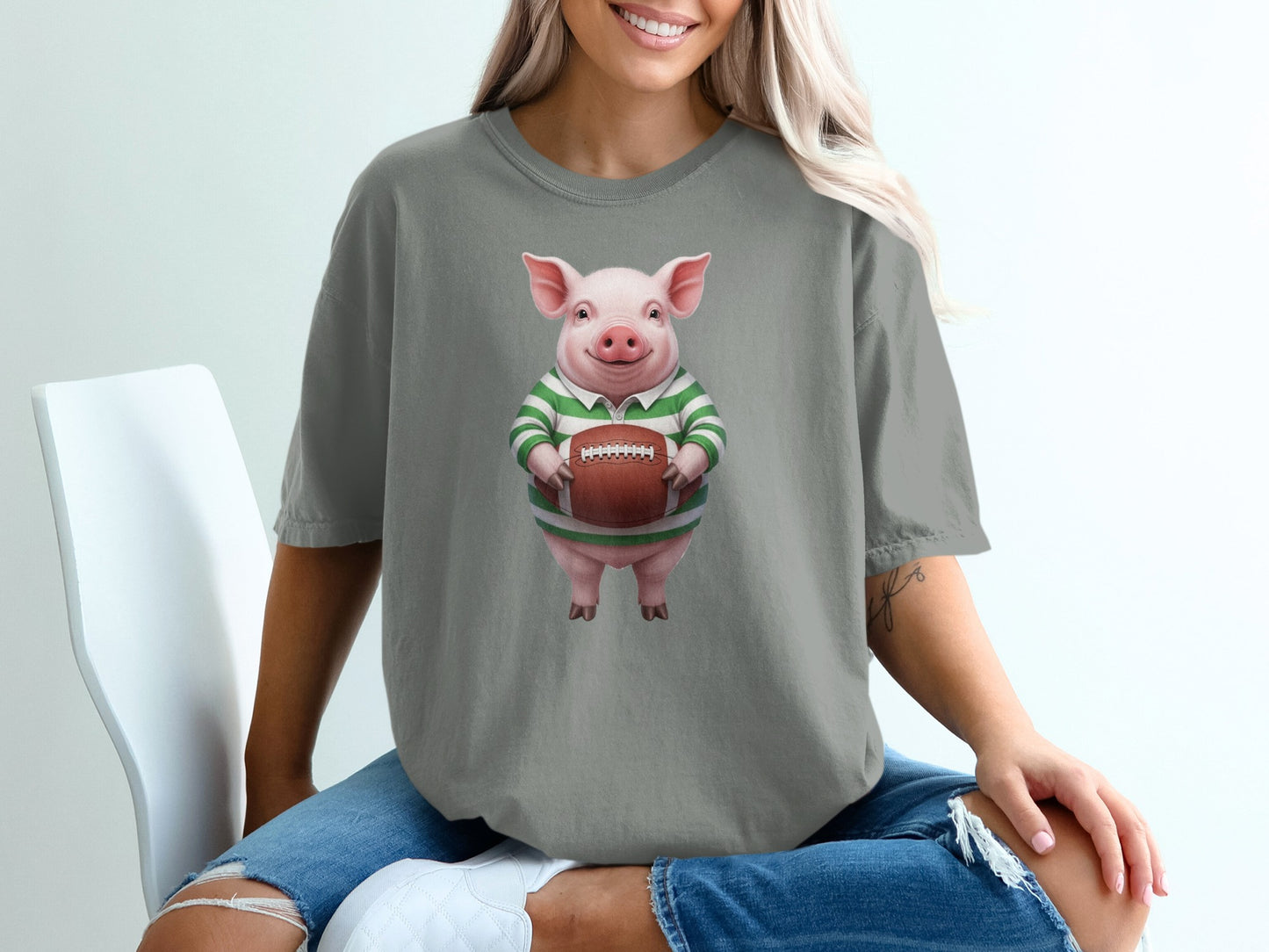 Pig wearing a green and white striped shirt holds a football.