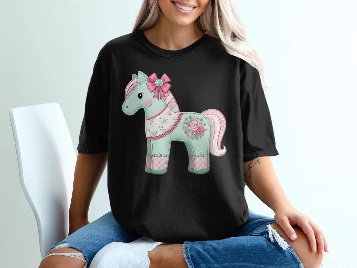 Black t-shirt with a pastel patchwork unicorn graphic.