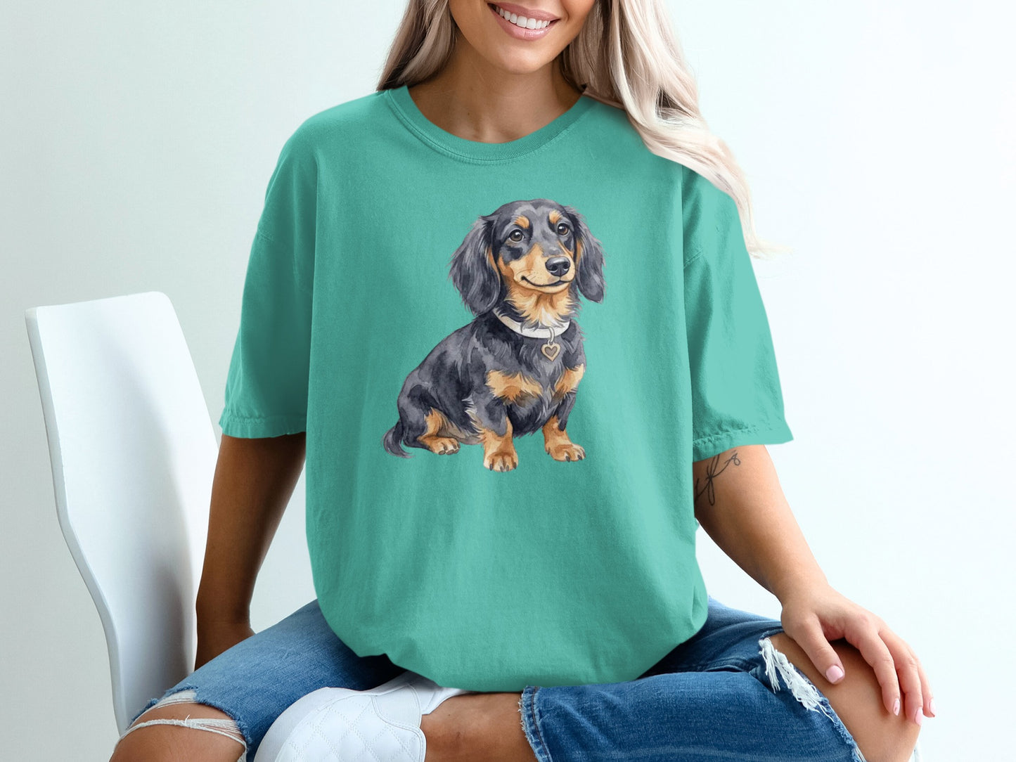 Teal t-shirt with watercolor dachshund wearing a heart pendant.