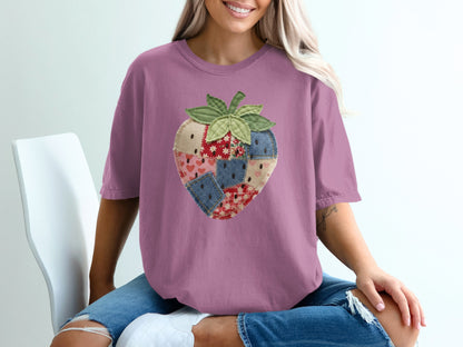 Purple t-shirt with a patched strawberry graphic.