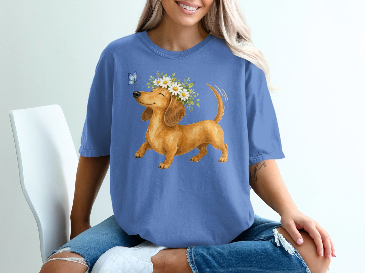 Dachshund with a flower crown and butterfly on blue t-shirt.