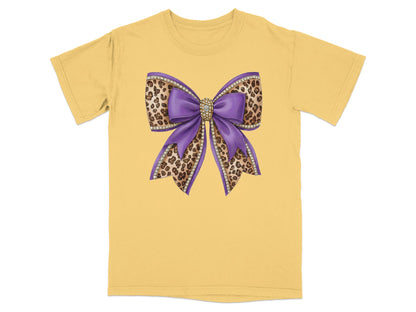 Purple sequin bow with leopard print accents on yellow t-shirt.