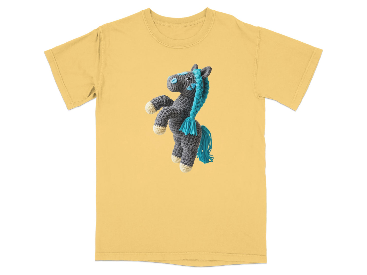 Crocheted gray horse with blue mane and tail on yellow t-shirt.