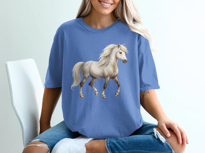 Light gray horse graphic on a blue t-shirt worn by a woman.