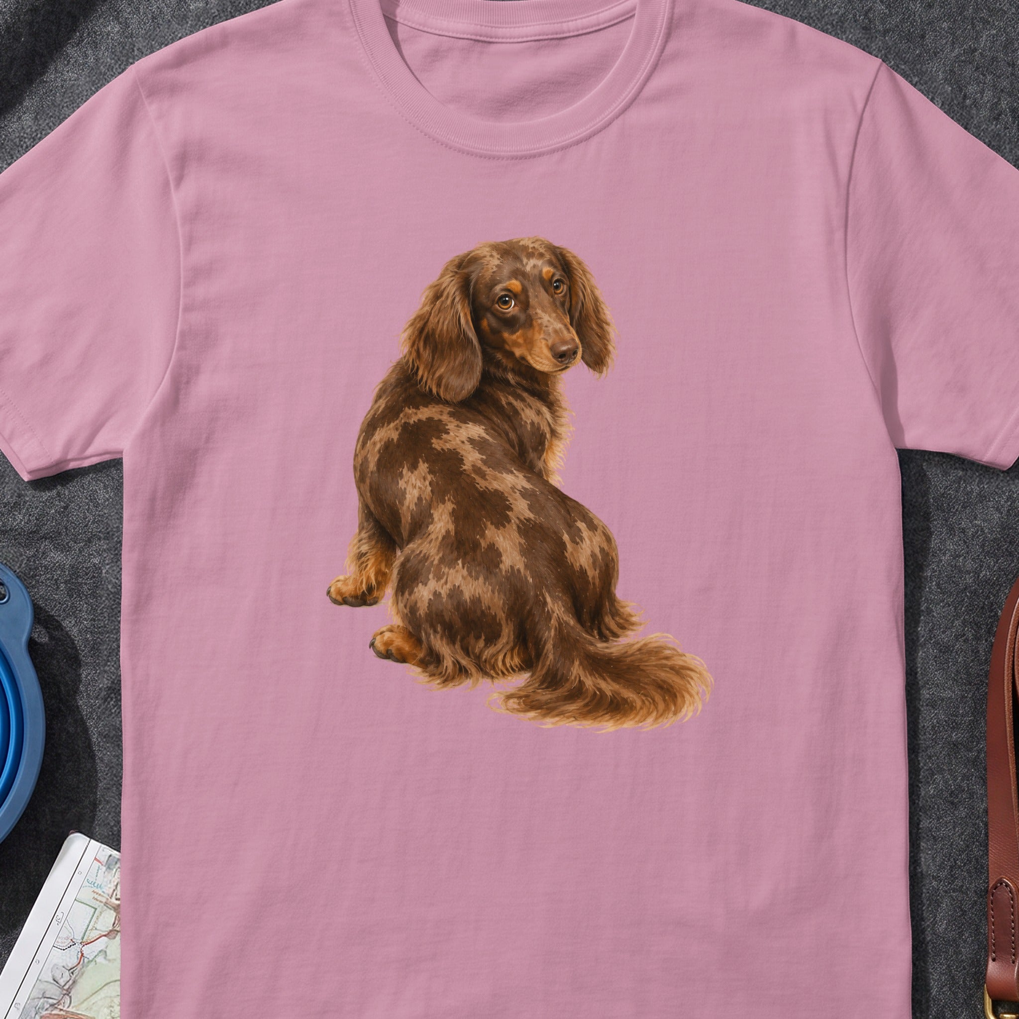 Pink t-shirt with a detailed illustration of a brown dapple dachshund sitting and looking back.
