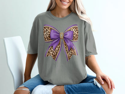 Purple glittery bow with leopard print accents on a gray t-shirt.