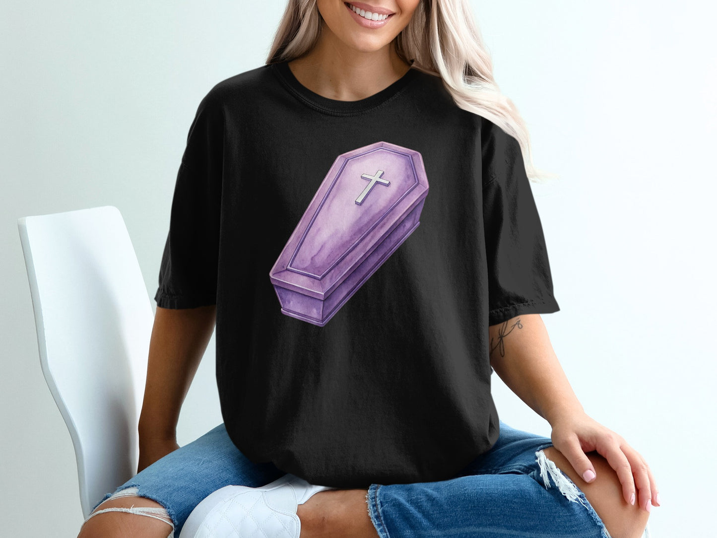 Black t-shirt with a purple coffin graphic and a silver cross.