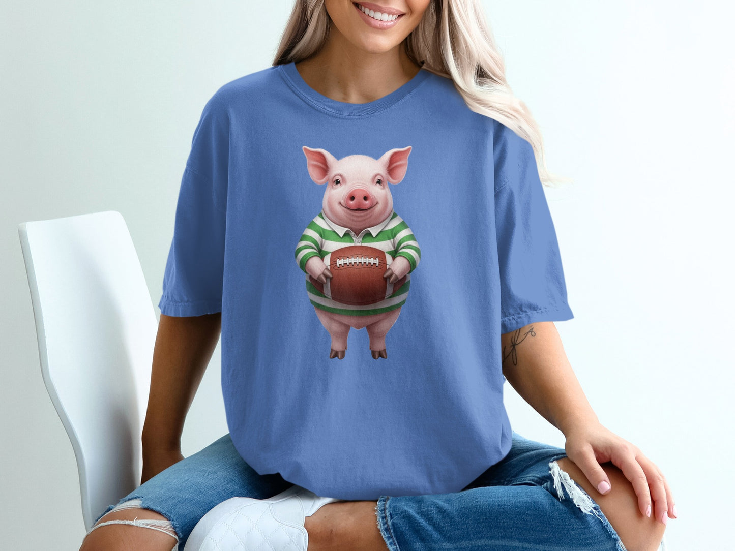 Pig in green and white striped shirt holding a football.