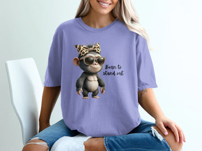 Monkey with sunglasses and leopard print bow wearing a purple t-shirt.