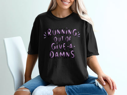 Black t-shirt with "RUNNING OUT OF GIVE-A-DAMS" text in purple.