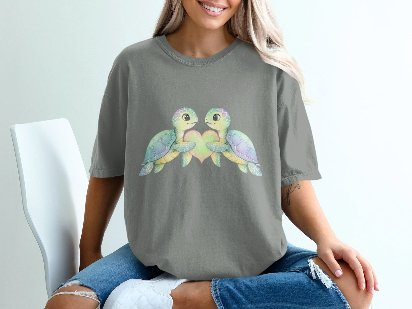 Two cartoon turtles embracing a heart, watercolor style on a grey t-shirt.