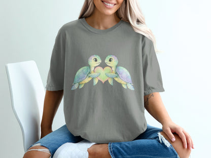 Two cartoon turtles embracing a heart, watercolor style on a grey t-shirt.