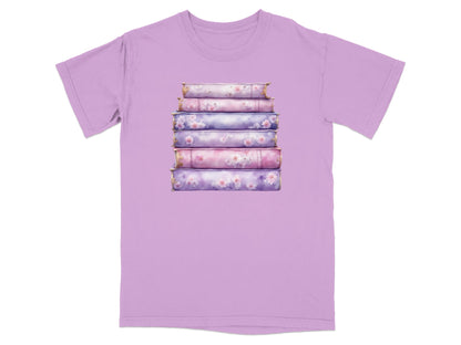 Stack of decorative books with floral accents on a purple t-shirt.
