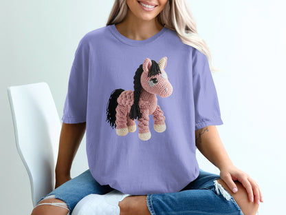 Purple t-shirt with a crocheted pink horse graphic.
