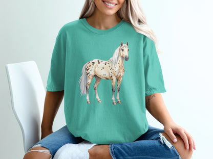 Appaloosa horse with black spots on a teal t-shirt.